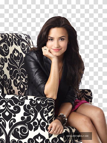 demi lovato, woman sitting on black and white damask sofa chair transparent background PNG clipart