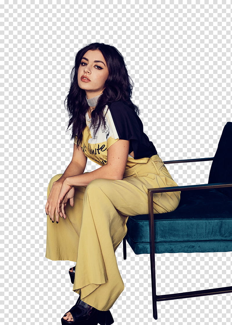 Charli XCX, woman sitting on teal fabric chair with black frame transparent background PNG clipart