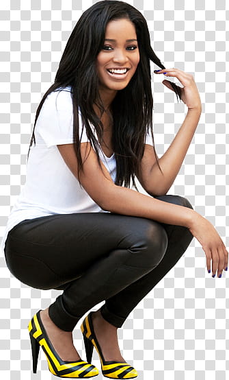 Keke Palmer wearing white crew-neck t-shirt and black pants sitting and smiling while touching her hair transparent background PNG clipart